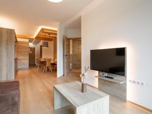 Una sala de estar con un televisor de pantalla plana grande. en Apart33 Top 2-10, en Haus im Ennstal
