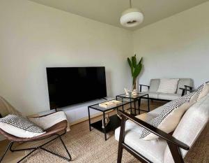 a living room with a large flat screen tv at La Maison Bleue, Jardin & Mer 300m in Dunkerque