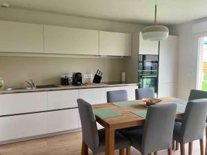 a kitchen with a wooden table and chairs in a kitchen at La Maison Bleue, Jardin & Mer 300m in Dunkerque