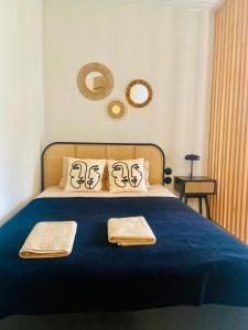a bedroom with a blue bed with two towels on it at AK Apartments 2 in Warsaw