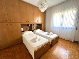 a bedroom with two beds and a chandelier at Appartamento alle Terrazze in Venice-Lido