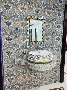 Un baño con un lavabo y un espejo en la pared. en Kartik, en Varanasi