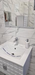 a white bathroom with a sink and a mirror at Villa Eliada in Tuzla +18 photos
