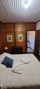 een groot bed in een kamer met houten wanden bij Pousada Florada na Serra - Apto 5 in Campos do Jordão