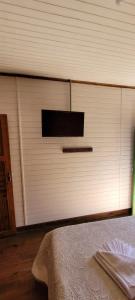 een witte garagedeur met een raam en een bed bij Pousada Florada na Serra - Apto 5 in Campos do Jordão