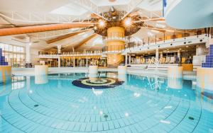 a large swimming pool in a large building at Vukmán Apartman in Sárvár