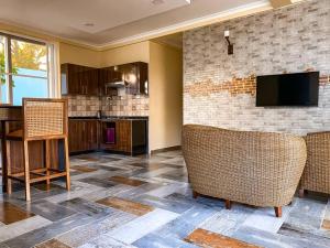ein Wohnzimmer mit zwei Stühlen und einem Flachbildfernseher in der Unterkunft SUN n SAND BEACH RESORT in Daressalam