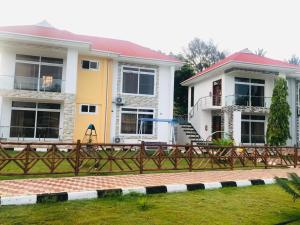 ein Haus mit einem Zaun davor in der Unterkunft SUN n SAND BEACH RESORT in Daressalam