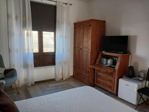 a bedroom with a bed and a television and a window at Casa del Valle 10 in Yaiza
