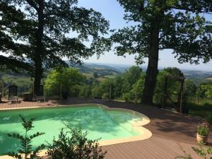 a swimming pool on a patio with a tree at Mountain retreat in the Pyrénées, glorious views, fire pit & pool - Sleeps 14 in Ossun-ez-Angles
