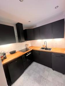 a kitchen with black cabinets and a sink at La Mignardise du Château in Lichtenberg