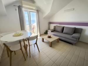 a living room with a couch and a table at Hektorovic poolside apartments in Bol +30 photos