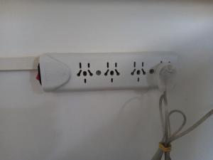 a white electrical outlet on a white wall with a wire at Urquiza - Habitación para turistas in Córdoba