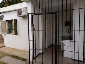 ein eisernes Tor vor einem weißen Haus in der Unterkunft Urquiza - Habitación para turistas in Cordoba + 15 Fotos