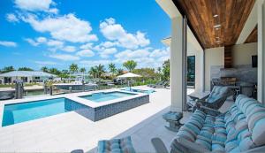 un patio extérieur avec une piscine et des chaises longues dans l'établissement Casa del Mar, à Marco Island