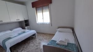 a room with two beds and a window at On the beach in Triscina
