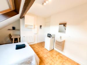 a small room with a bed and a refrigerator at Anh Dao 2 - Studio, centre ville, tiamconciergerie in Champs-Sur-Marne
