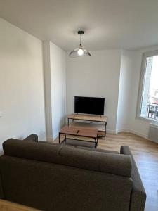 ein Wohnzimmer mit Couch und Flachbildfernseher in der Unterkunft Appartement Moderne in Gennevilliers