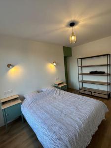 ein Schlafzimmer mit einem großen Bett und zwei Nachttischen in der Unterkunft Appartement Moderne in Gennevilliers