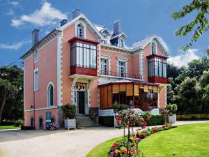 a large pink house with flowers in front of it at La Belle brise in Granville