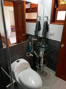 Un baño con inodoro, lavabo y espejo. en Casa familiar RS, en Villa de Leyva 31 fotos más