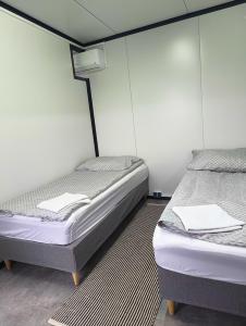 two twin beds in a room withthritisthritisthritisthritisthritisthritisbestosbestosbestos at Ostoja Czersk Góra Kalwaria Zamek Królowej Bony Domki całoroczne in Czersk +33 photos