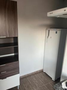 a white refrigerator in a room with a kitchen at HOUSE DORA AP 03 com AR CONDICIONADO in Campo Grande