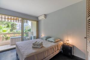a bedroom with a large bed and a large window at TANIT Piscine, 6 couchages, Parking in Antibes