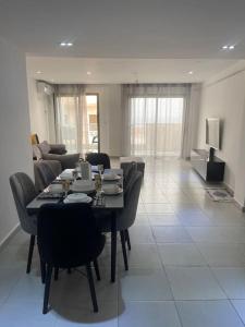 a living room with a table and chairs and a couch at Rue de Paris - Plage Saint Germain - vue sur mer - in 'Aïn el Turk
