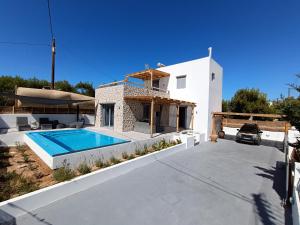 a villa with a swimming pool and a house at Vilianna in Zefiría
