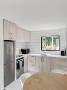 a kitchen with wooden cabinets and a table and a window at Hagley Park Townhouse in Christchurch
