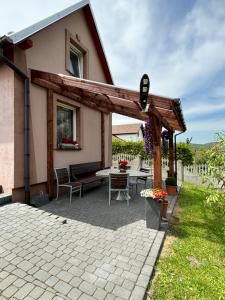 a patio with a table and a house at Agroturystyka ‚U Misia’ in Krzywopłoty