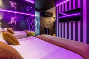two beds in a room with purple lighting at Villa Close Port Nature in Cap d'Agde