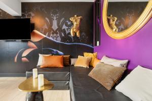 a living room with purple walls and a black couch at Villa Close Port Nature in Cap d'Agde