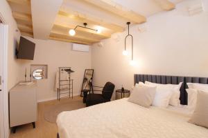 a bedroom with a bed and a chair in a room at Heritage House Kaleta in Hvar
