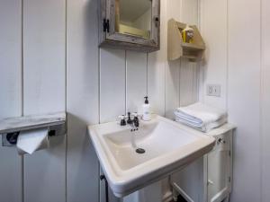 a bathroom with a white sink and a mirror at Eastside Bungalow in Livingston +17 photos