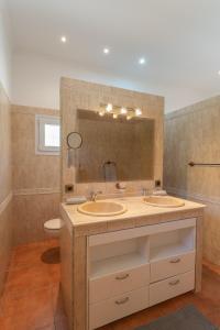 a bathroom with two sinks and a mirror at Retiro Sol - Casa Joni in Orba