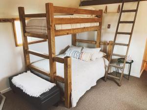 a bedroom with two bunk beds and a chair at Blackhawks Nest in Livingston