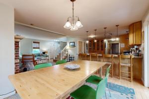 Un comedor y una cocina con mesa y sillas de madera. en Sea Pine Palace, en Wellfleet