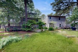 Un patio vacío con una casa con un banco. en Sea Pine Palace, en Wellfleet