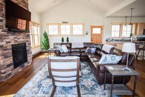 a living room with a leather couch and a fireplace at Sapphire Solace in Emigrant