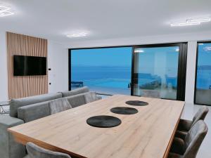 a wooden table in a living room with a couch at Villa Sea level with BEAUTIFUL VIEW, Medveja in Lovran