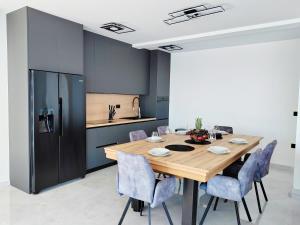 a dining room with a wooden table and blue chairs at Villa Sea level with BEAUTIFUL VIEW, Medveja in Lovran