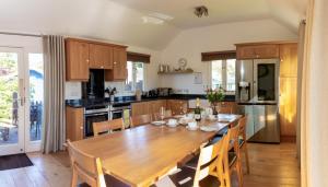 a large kitchen with a wooden table and chairs at Rookery Cottage in Paignton