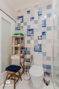 a bathroom with a toilet and a blue and white tiled wall at São Lourenço Apt - Amazing terrace with Sea View in Ericeira