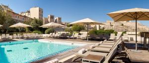 a swimming pool with lounge chairs and umbrellas at Radisson Blu Hotel Marseille Vieux Port in Marseille