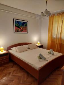 a bedroom with a large bed with two towels on it at Apartment Roglić in Rab