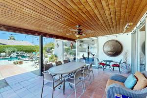 un patio con techo de madera, mesa y sillas en Avenida Mendoza Escape Permit# 67701, en La Quinta