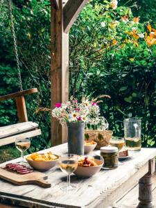 a table with bowls of food and glasses of wine at Chalet chaleureux à Marigny-l'Église avec vue sur lac et montagne in Marigny-lʼÉglise