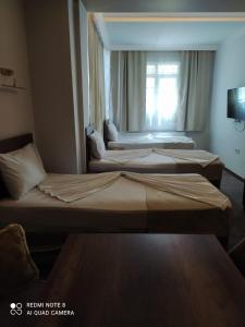 three beds in a hotel room with a window at Center Room Otel in Yenimahalle